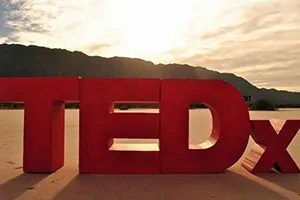 TEDx letters display on a beach